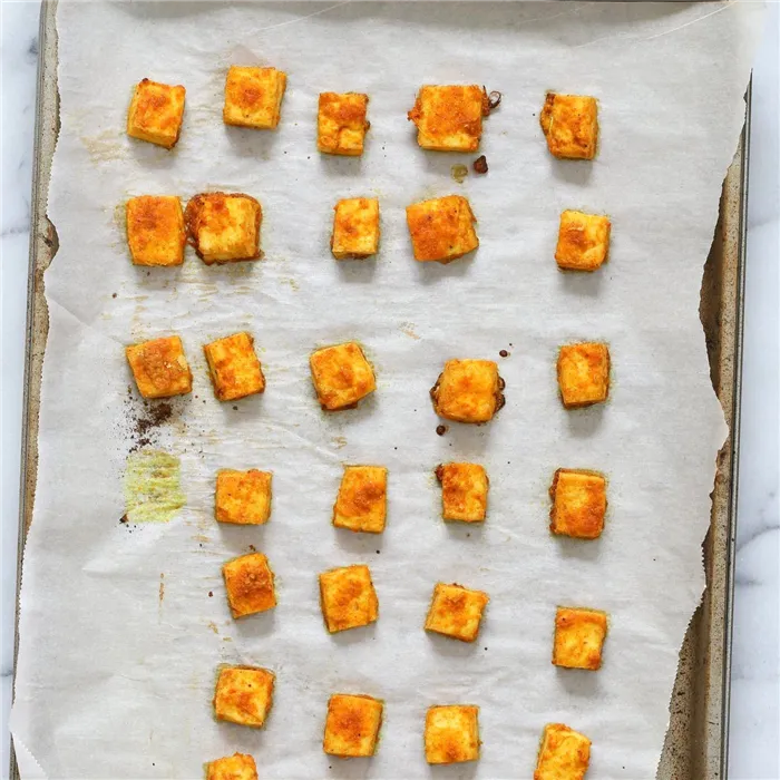 Marinated Tofu Cubes baked on Parchment lined baking sheet for Indian Butter Tofu Masala dish